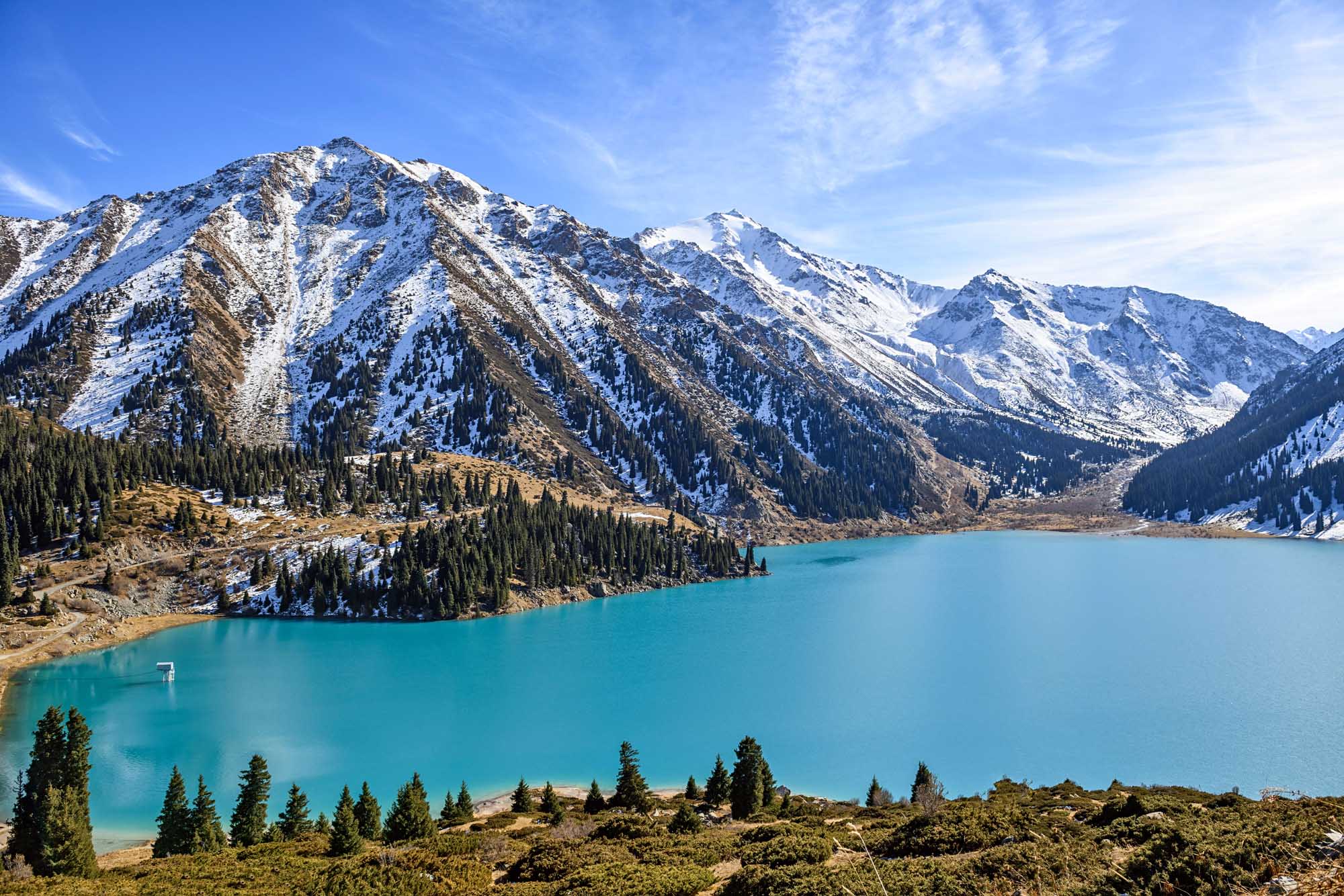 Big Almaty Lake in Winter A stunning alpine lake with brilliant turquoise waters surrounded by snow-capped peaks and dense