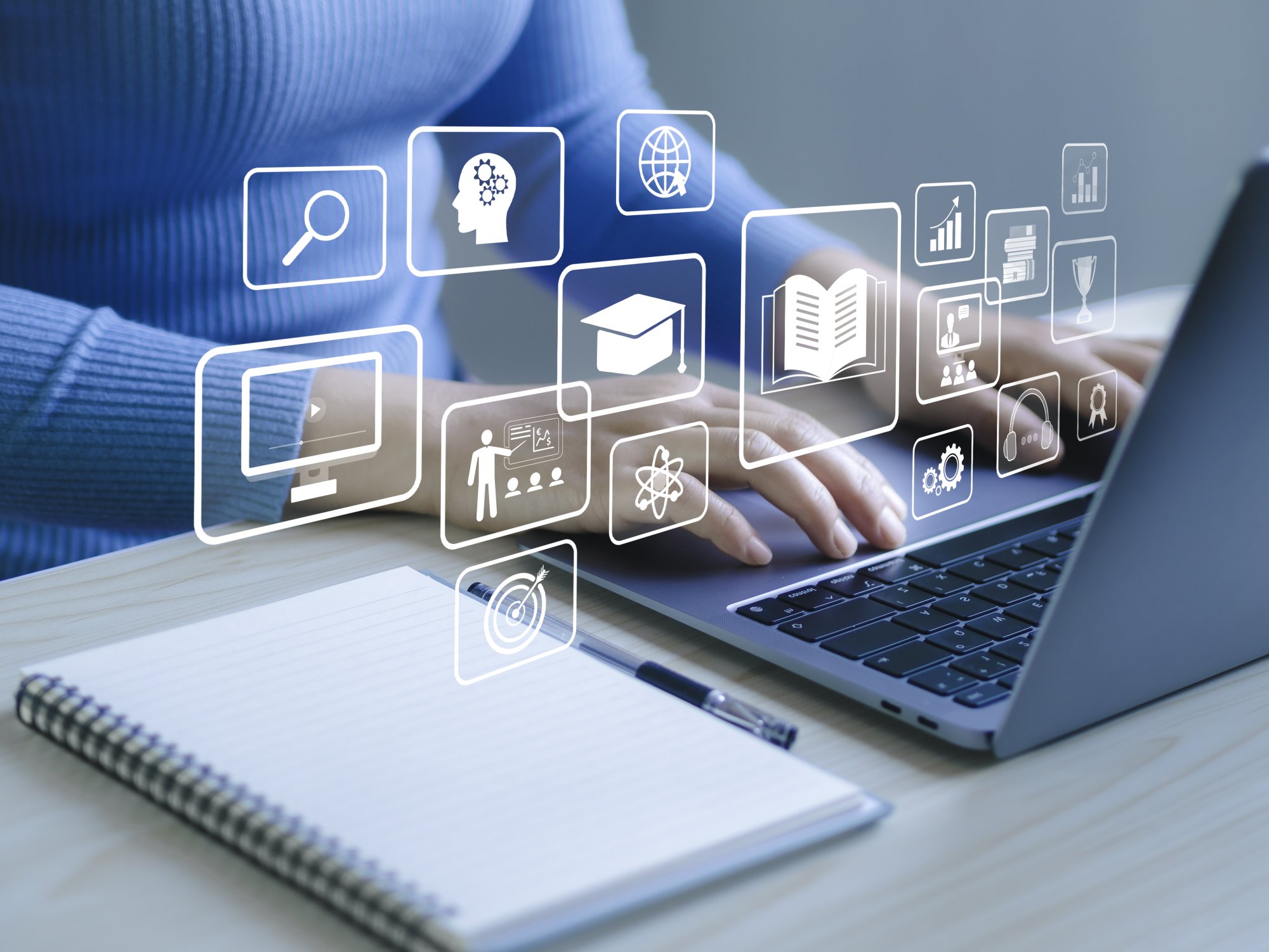 A professional workspace scene showing a person using a laptop with holographic overlays