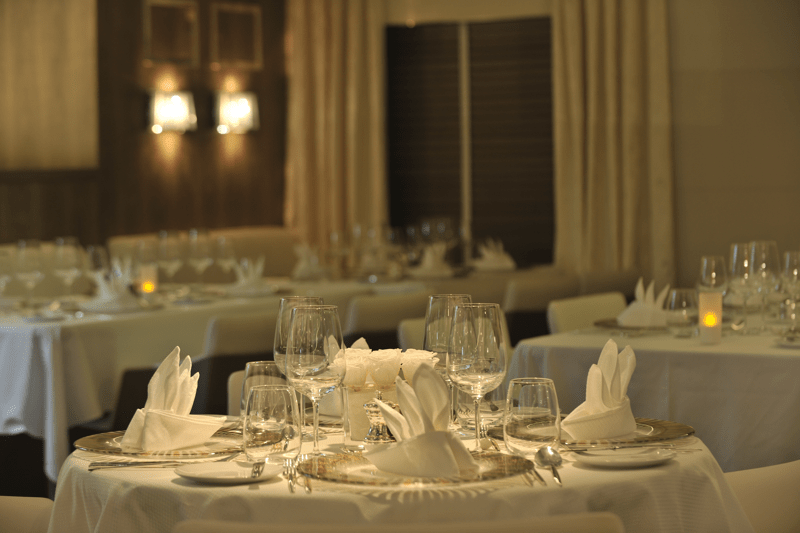 An elegant formal dining room aboard the Ponant cruise ship Le Boréal, featuring a round table set