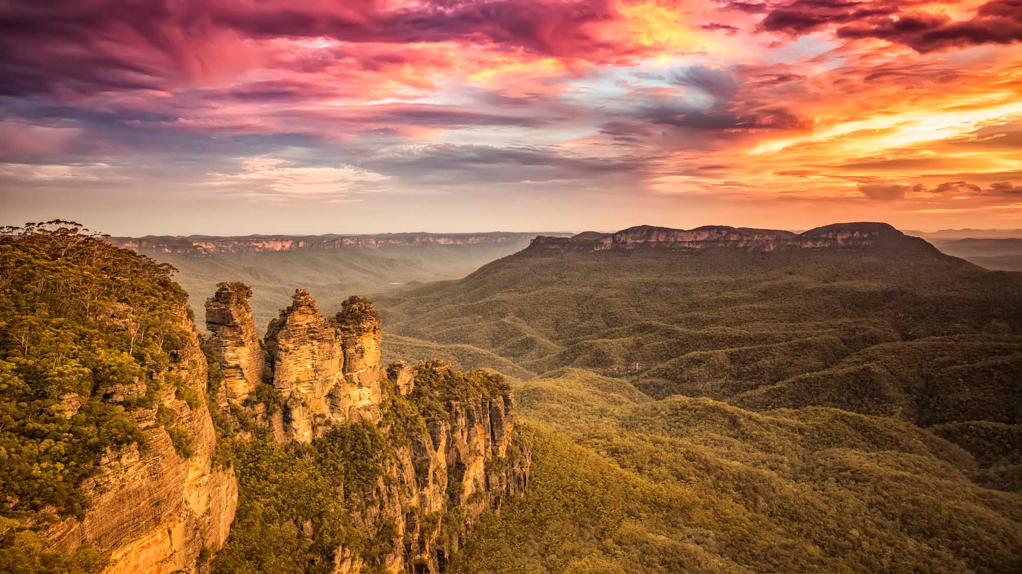 A dramatic sunset view of the iconic Three Sisters rock formation in Australia's Blue Mountains
