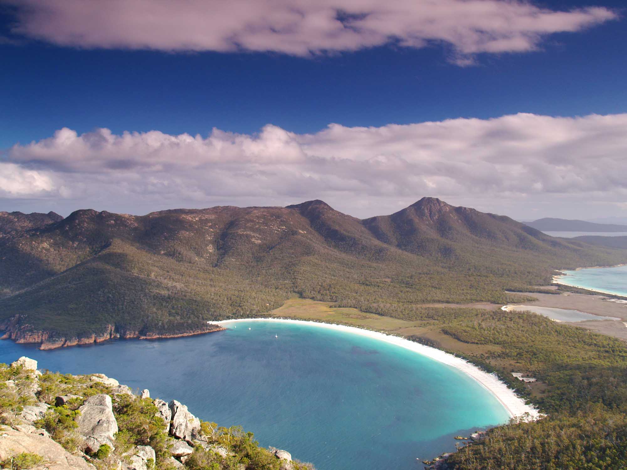 An aerial view of the iconic Wineglass Bay in Freycinet National Park, Tasmania, featuring pristine