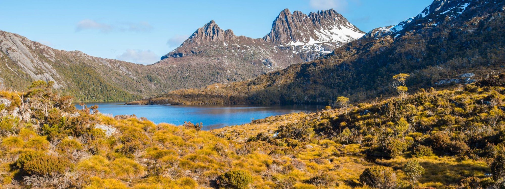 A stunning alpine landscape featuring Cradle Mountain's distinctive jagged peaks rising above