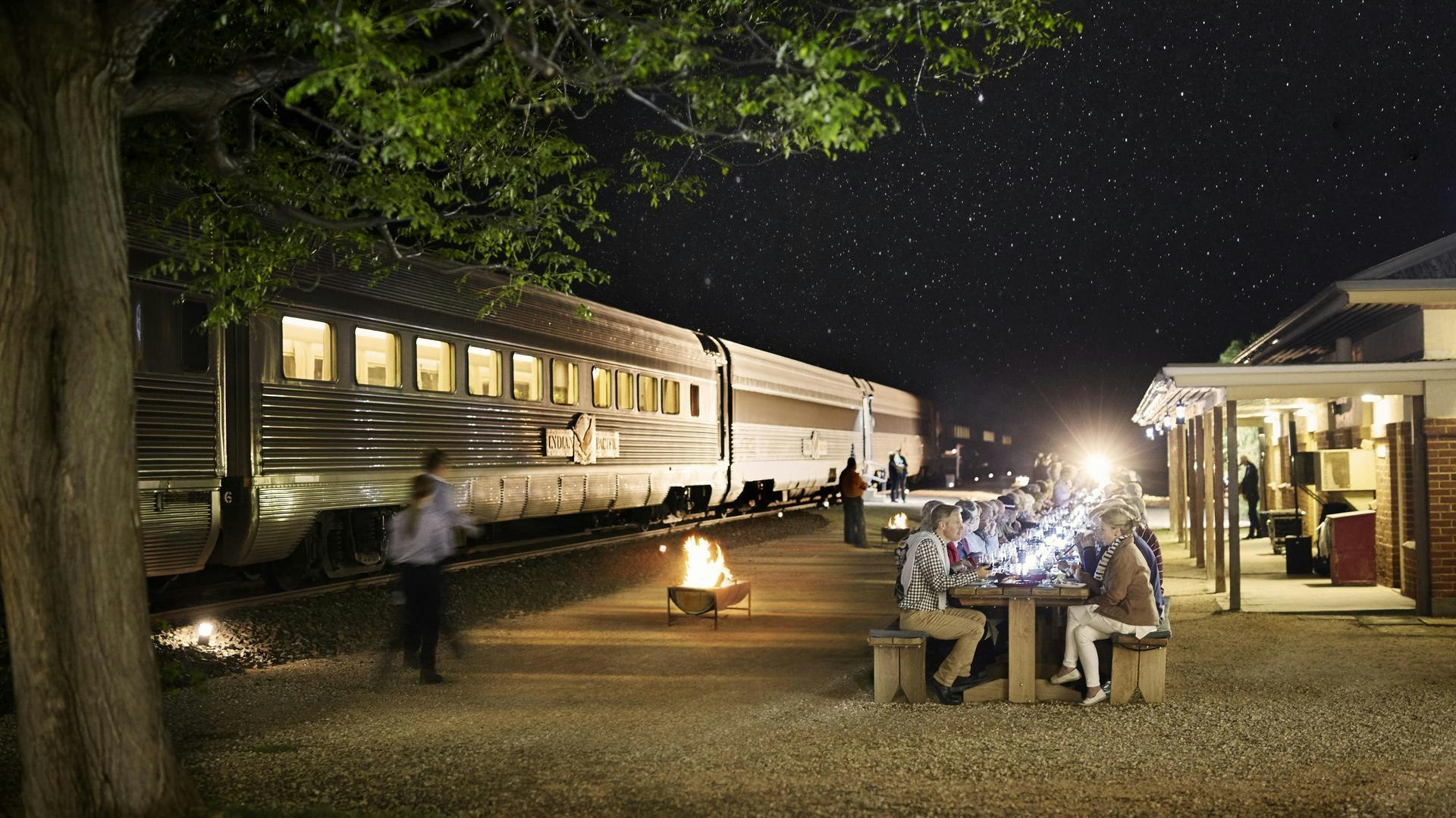 Indian Pacific Train Outdoor Dining Experience Passengers enjoy an evening meal outdoors beside the Indian Pacific luxury train under a starlit