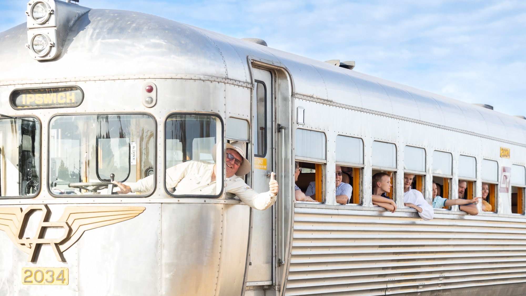 Vintage Streamliner Train with Passengers A classic streamliner passenger train numbered 2034 with silver aluminum exterior and art deco