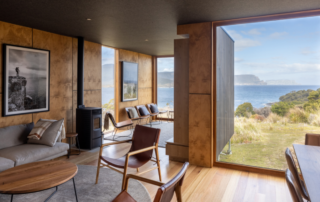 A modern, minimalist interior space featuring warm timber and bronze accents, with expansive