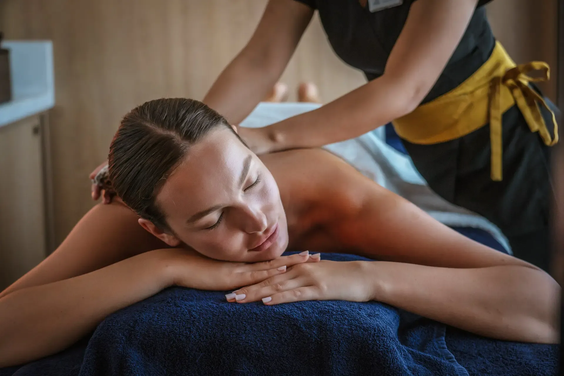 A woman receives a professional back massage from a spa therapist in a serene spa environment
